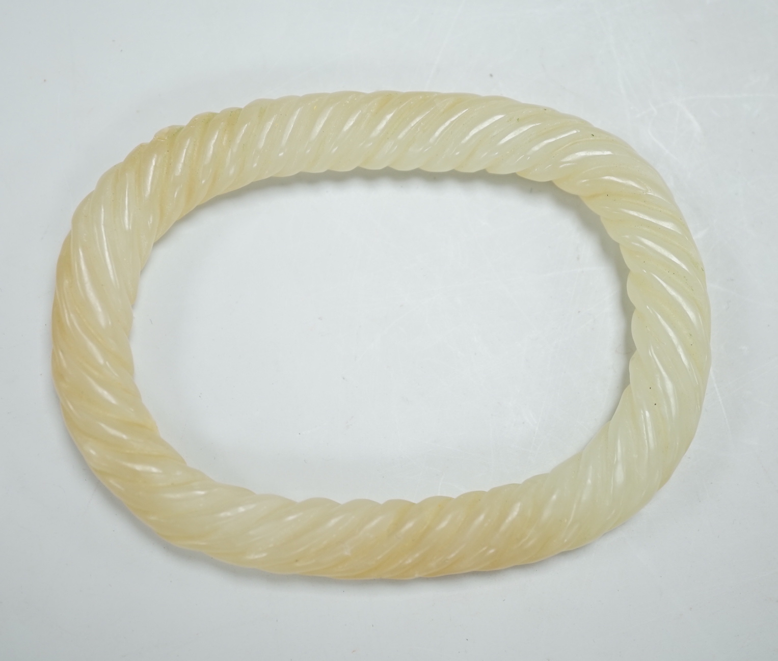 A Chinese pale celadon jade rope twist bangle, 8.3cm wide